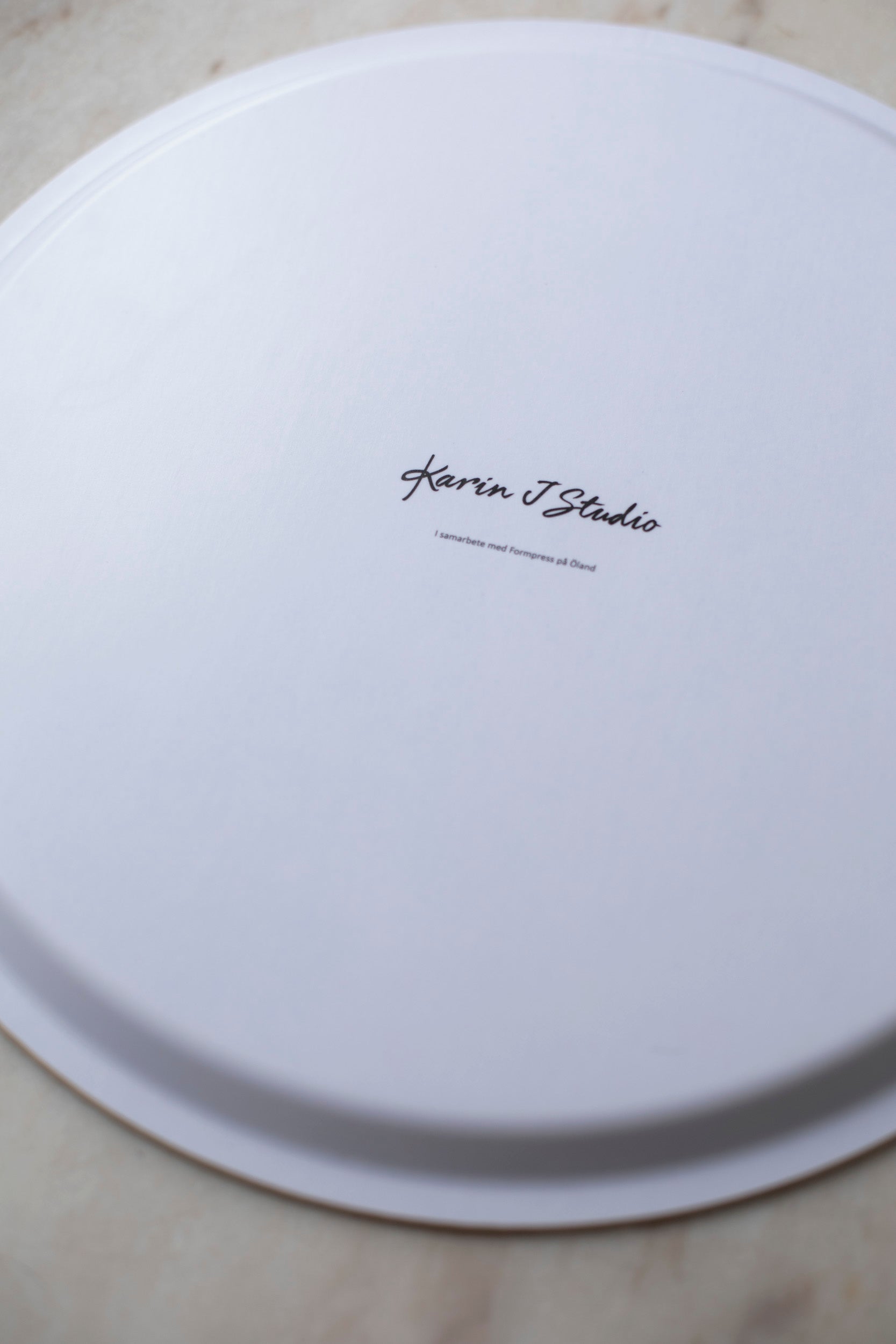 Baksidan av Karin J Studios brickor som är tillverkade i Sverige av trä.